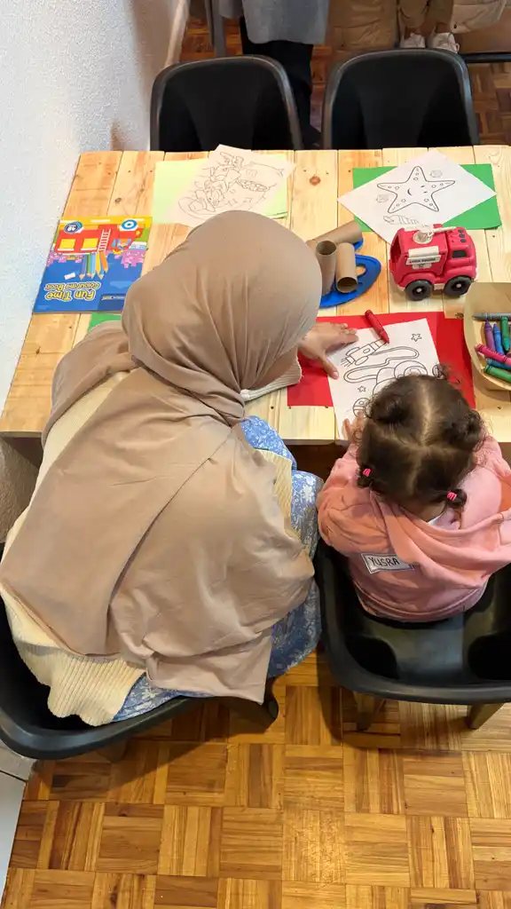 A teacher helping a child colour