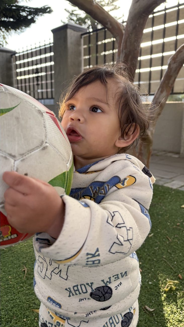 A Dewdrop child playing with a ball outdoors